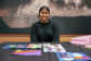 A photo of Swati Ravi with her quilt on the table.